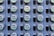 A grid of multiple electric utility meters mounted on a panel. The arrangement is orderly, with each meter featuring a transparent cover and a digital display, some of which have protective black covers next to them.