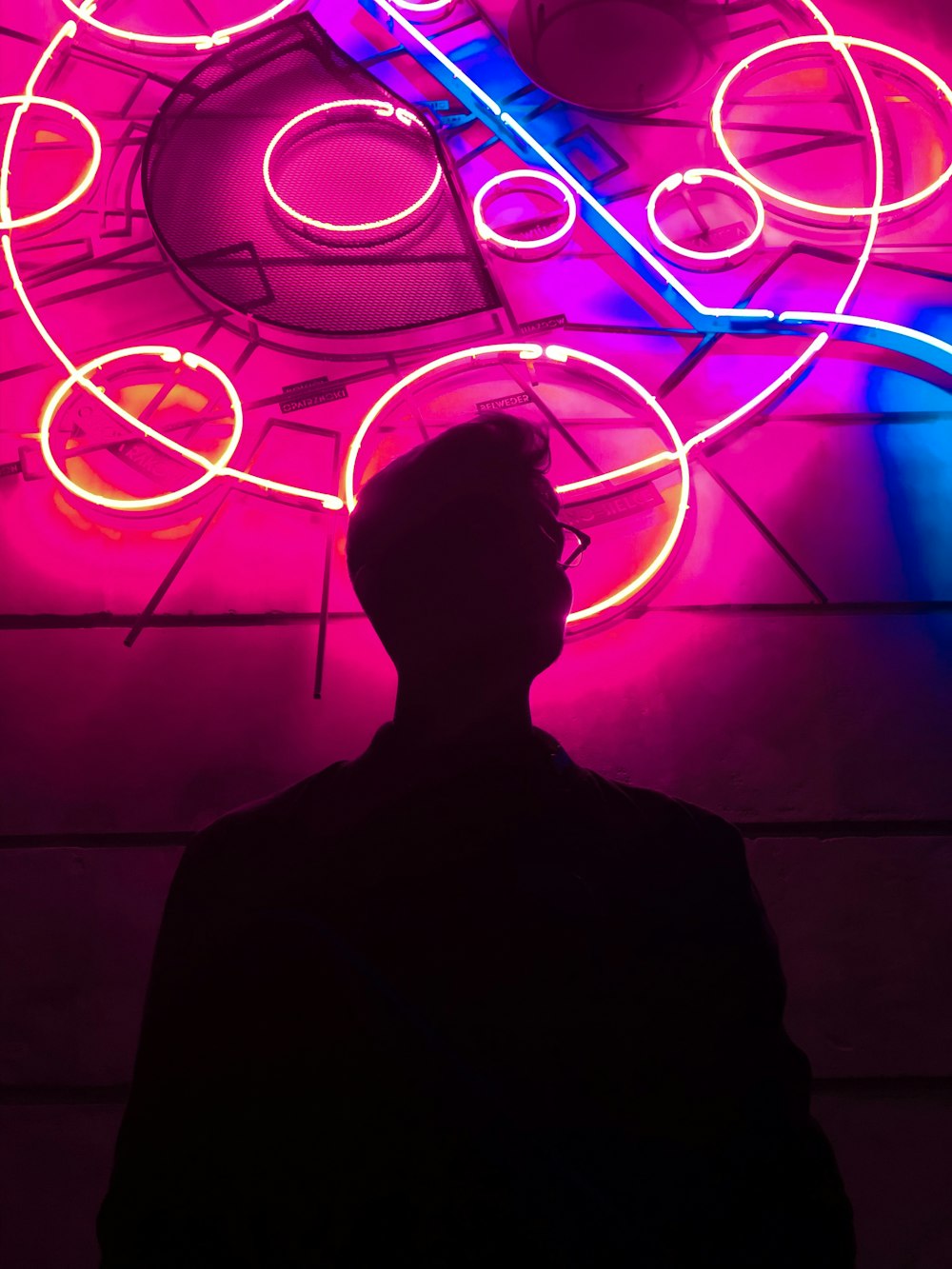 silhouette of man standing in front of neon light