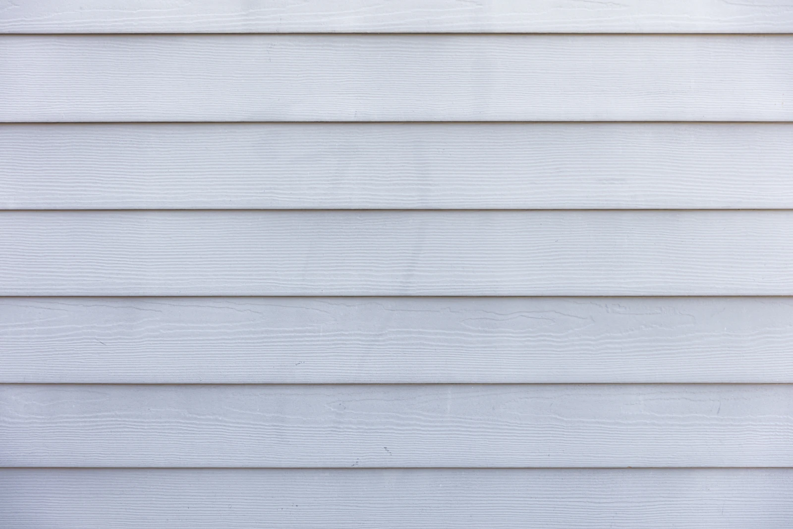 Close view of white wood siding boards on a house exterior.