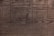 Weathered wooden surface with distinct grain patterns and subtle variations in color.
