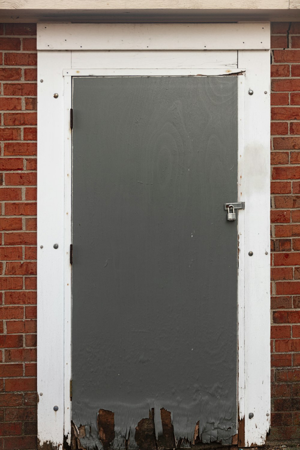 白いスチール製のドアノブ付きの黒い木製ドア