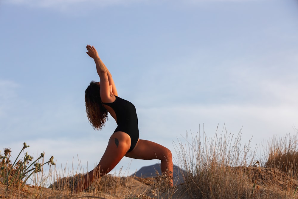 woman in black tank top and black shorts standing on brown grass field