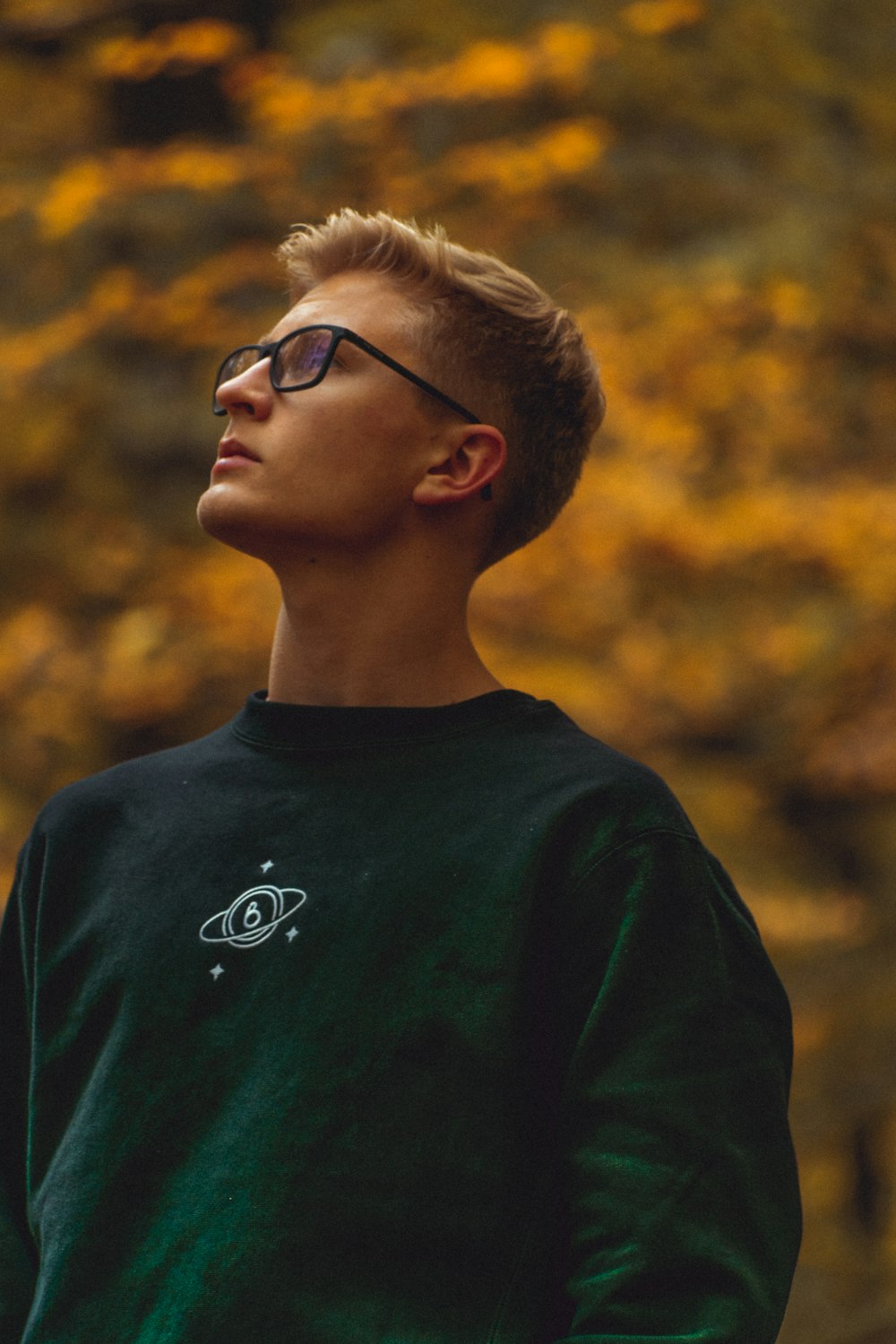 ragazzo in camicia girocollo verde che indossa occhiali da vista con montatura nera