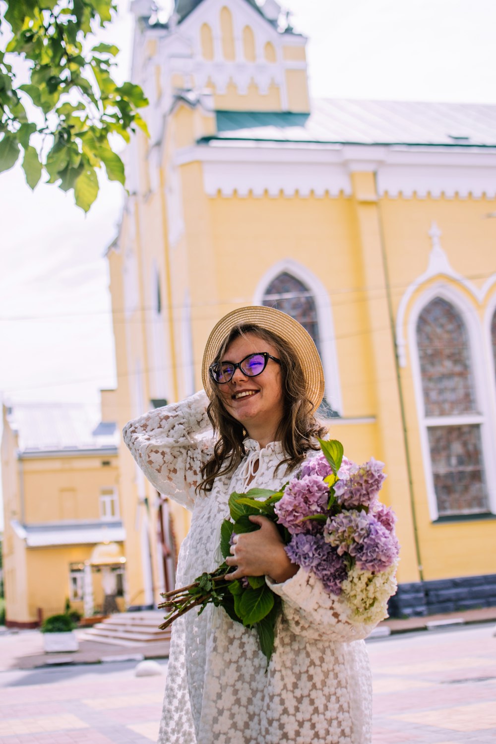 woman in white and brown floral long sleeve shirt holding bouquet of flowers