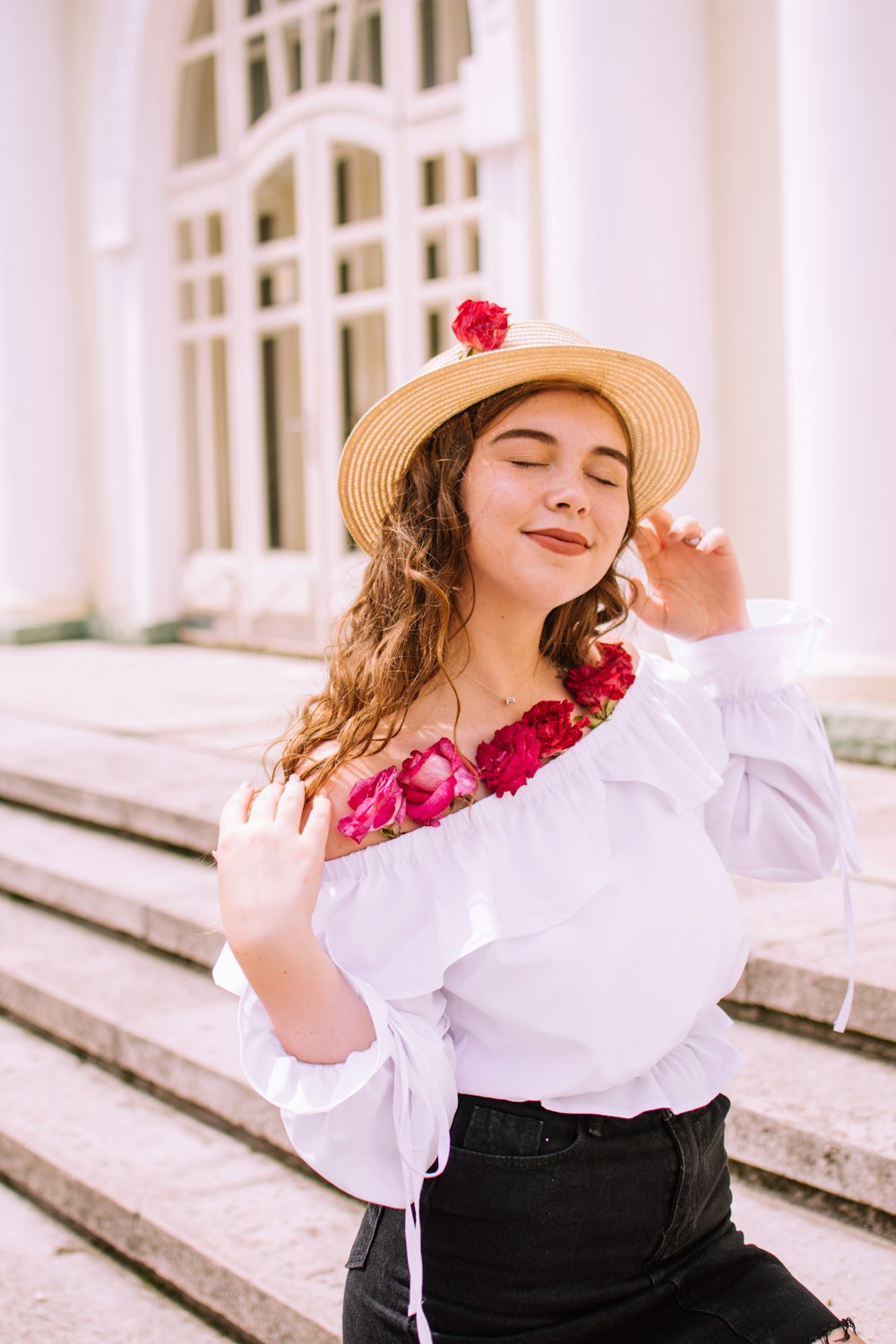 donna in abito bianco a maniche lunghe che indossa cappello di paglia marrone