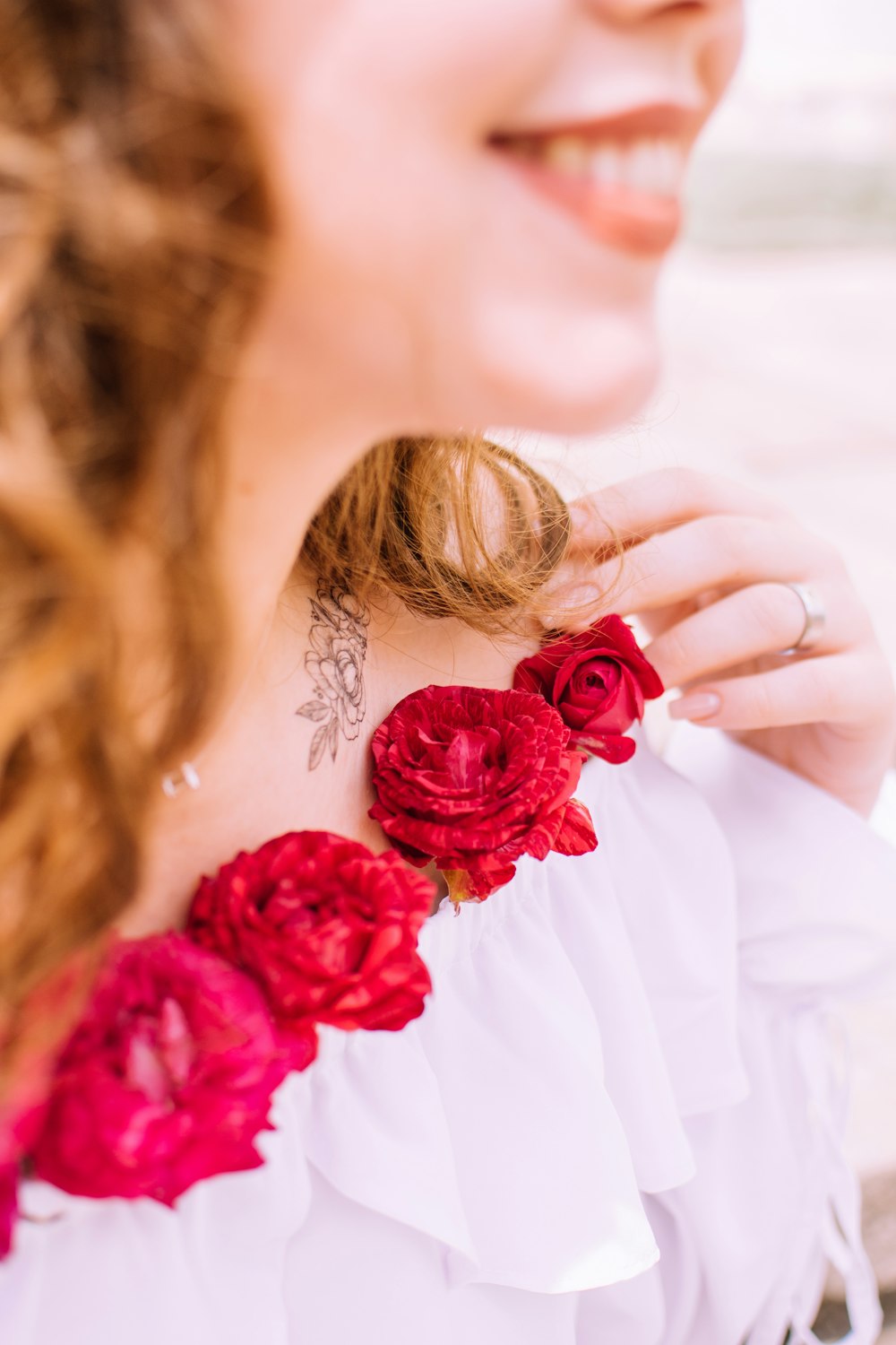 woman in white dress holding red rose