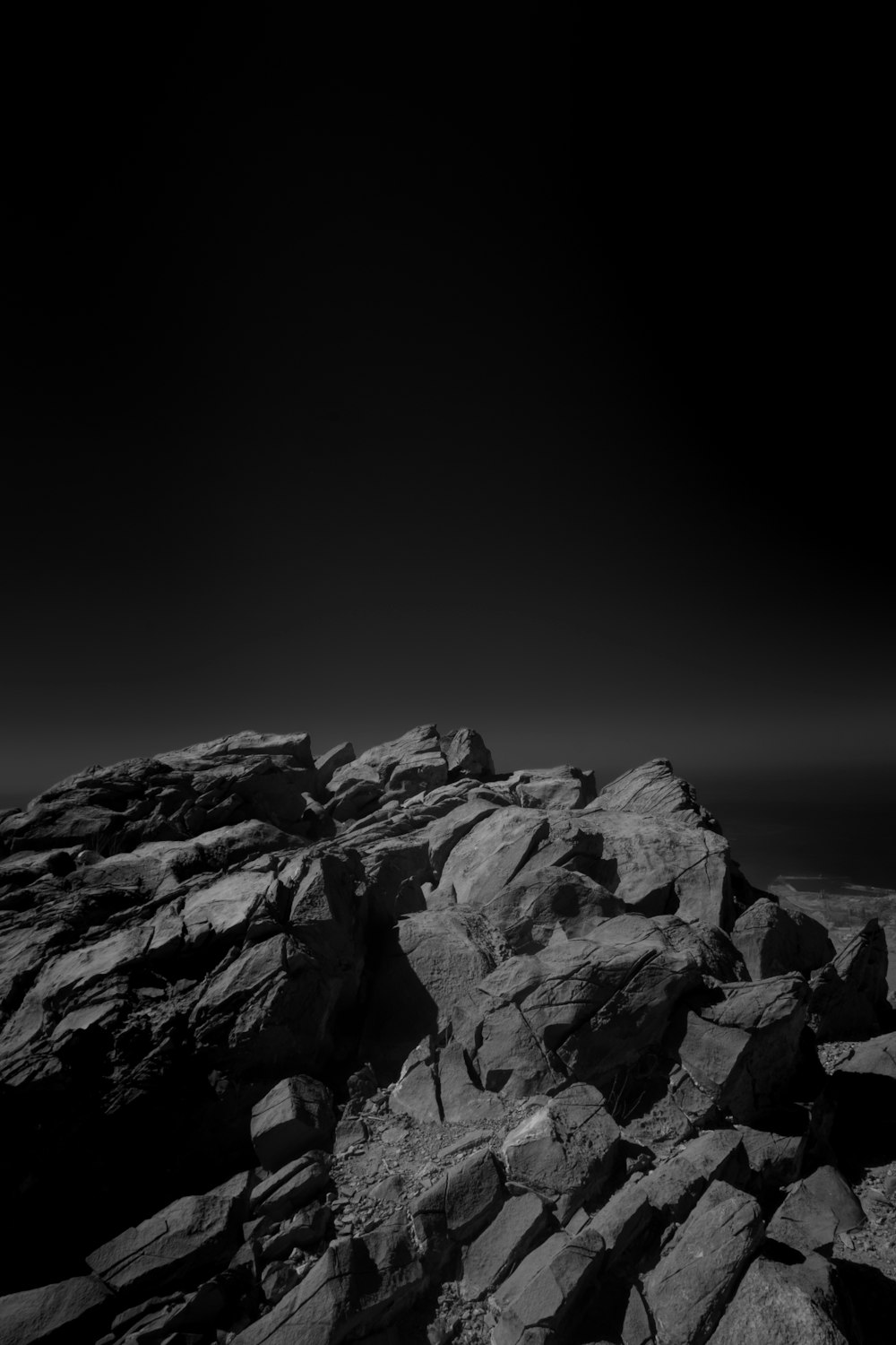 foto em escala de cinza da montanha rochosa