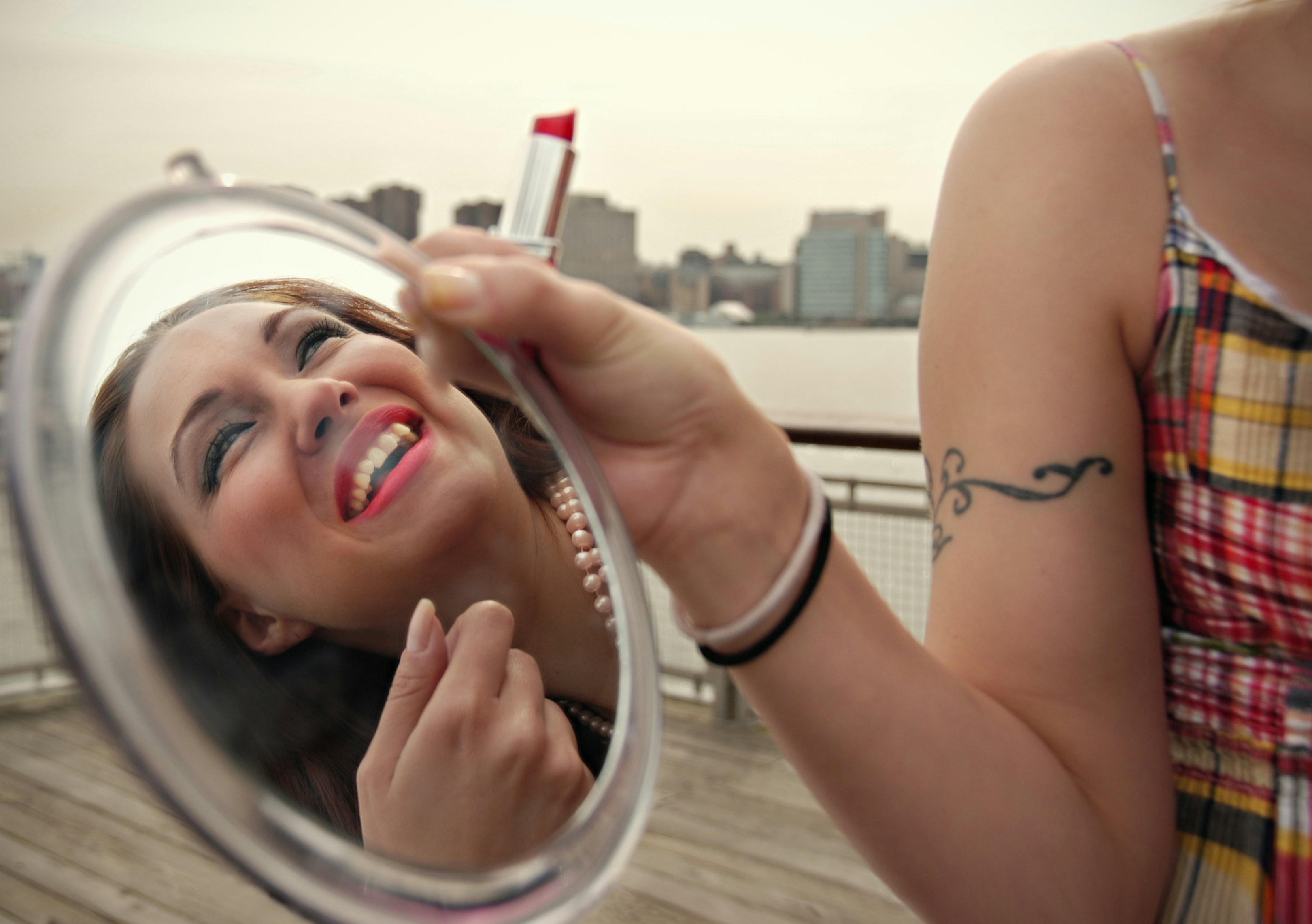 woman in black tank top holding pink lipstick