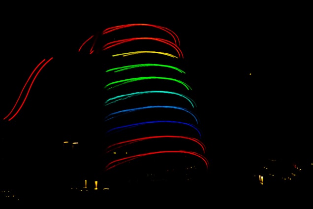 A dark background accentuated by a spiral of glowing neon lights in multiple colors, including red, green, blue, and yellow.