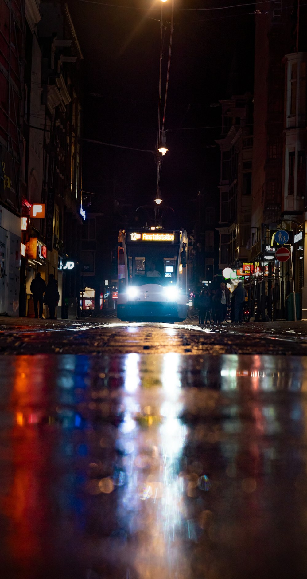 a city street at night with a bus on the street