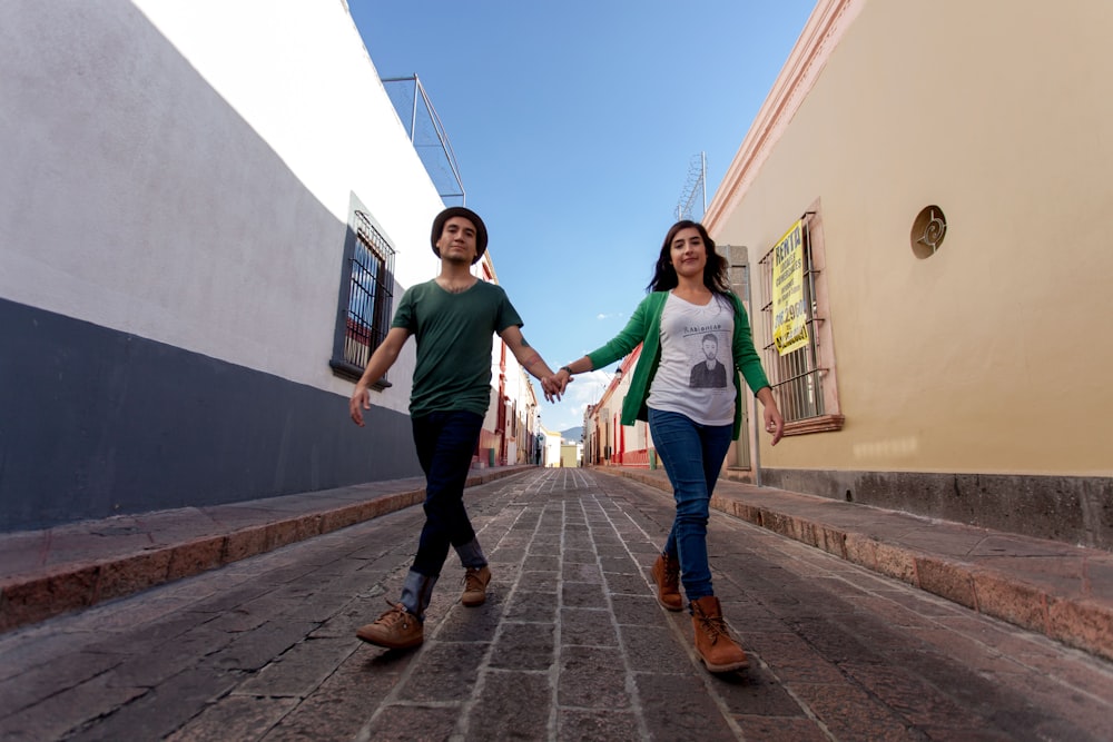 man in green crew neck t-shirt and blue denim jeans standing beside woman in green