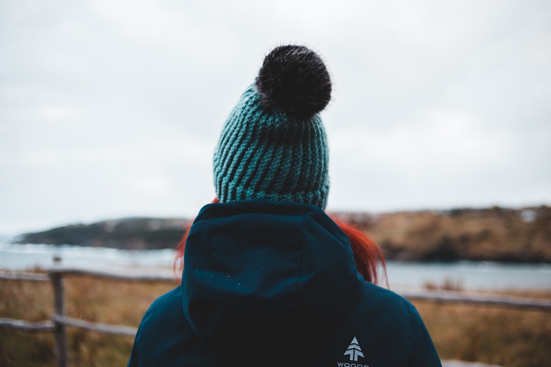 person in black knit cap and red jacket