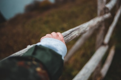 Close-up of hands attaching fence panels, showcasing craftsmanship and attention to detail.