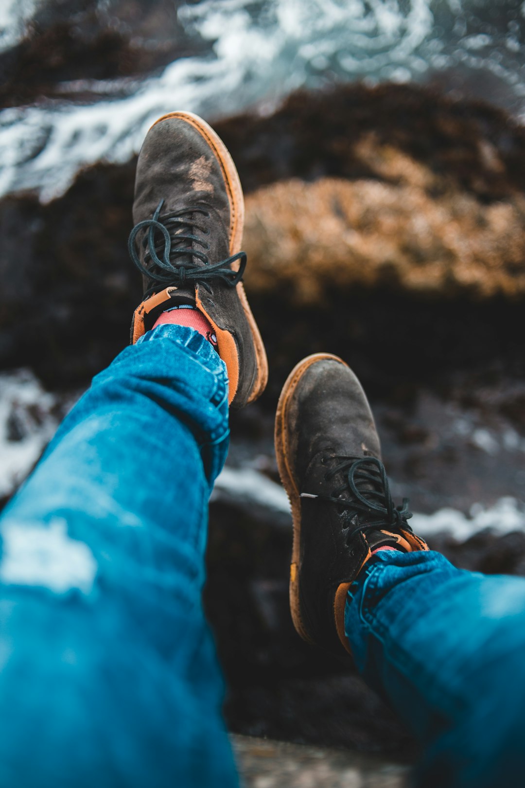 person in blue denim jeans and brown leather boots