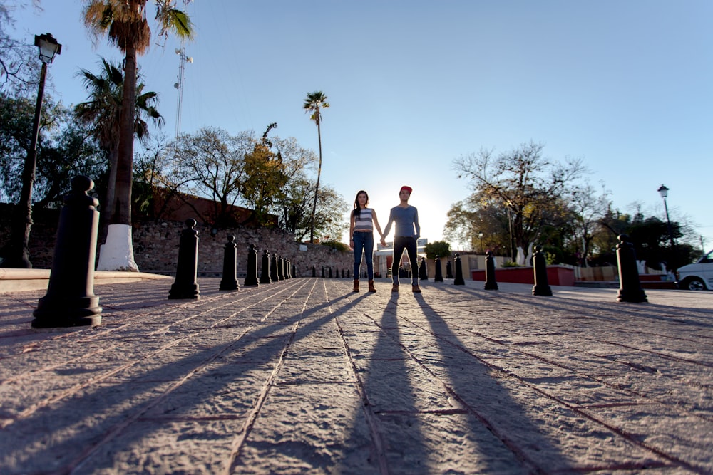 man and woman walking on gray concrete pathway during daytime
