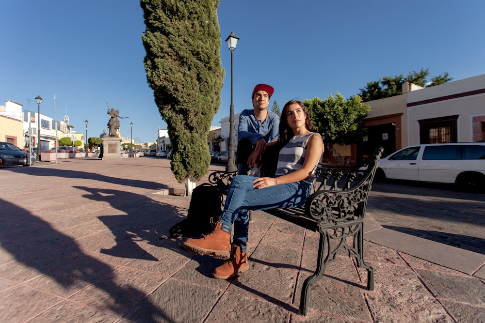 man and woman sitting on black metal chairs under blue sky during daytime