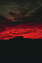 A sleek dark-colored truck leaving the port of Manzanillo under a dramatic sky.