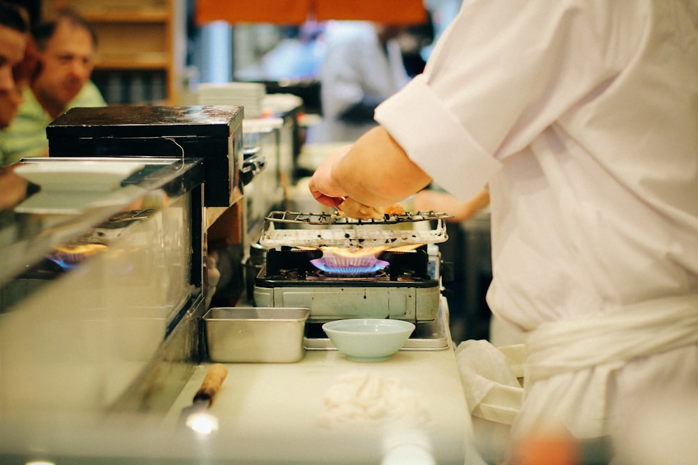 person in white chef uniform holding stainless steel tray
