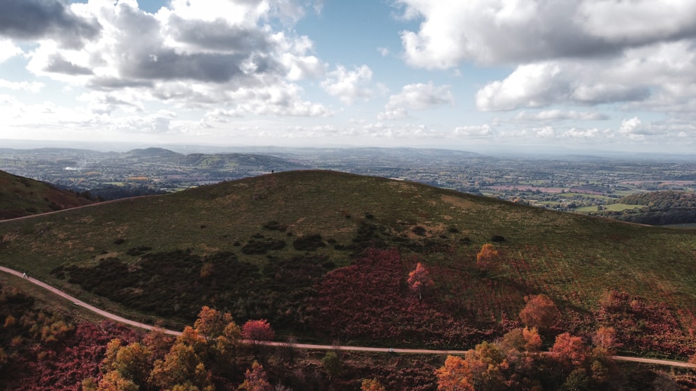 montañas verdes y marrones bajo nubes blancas y cielo azul durante el día