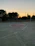 Close-up of a well-used basketball resting on an outdoor court at sunset.