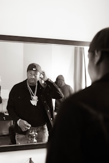 A stylish influencer adjusting his tailored jacket in front of a mirror, blending fashion with a subtle fragrance mist.