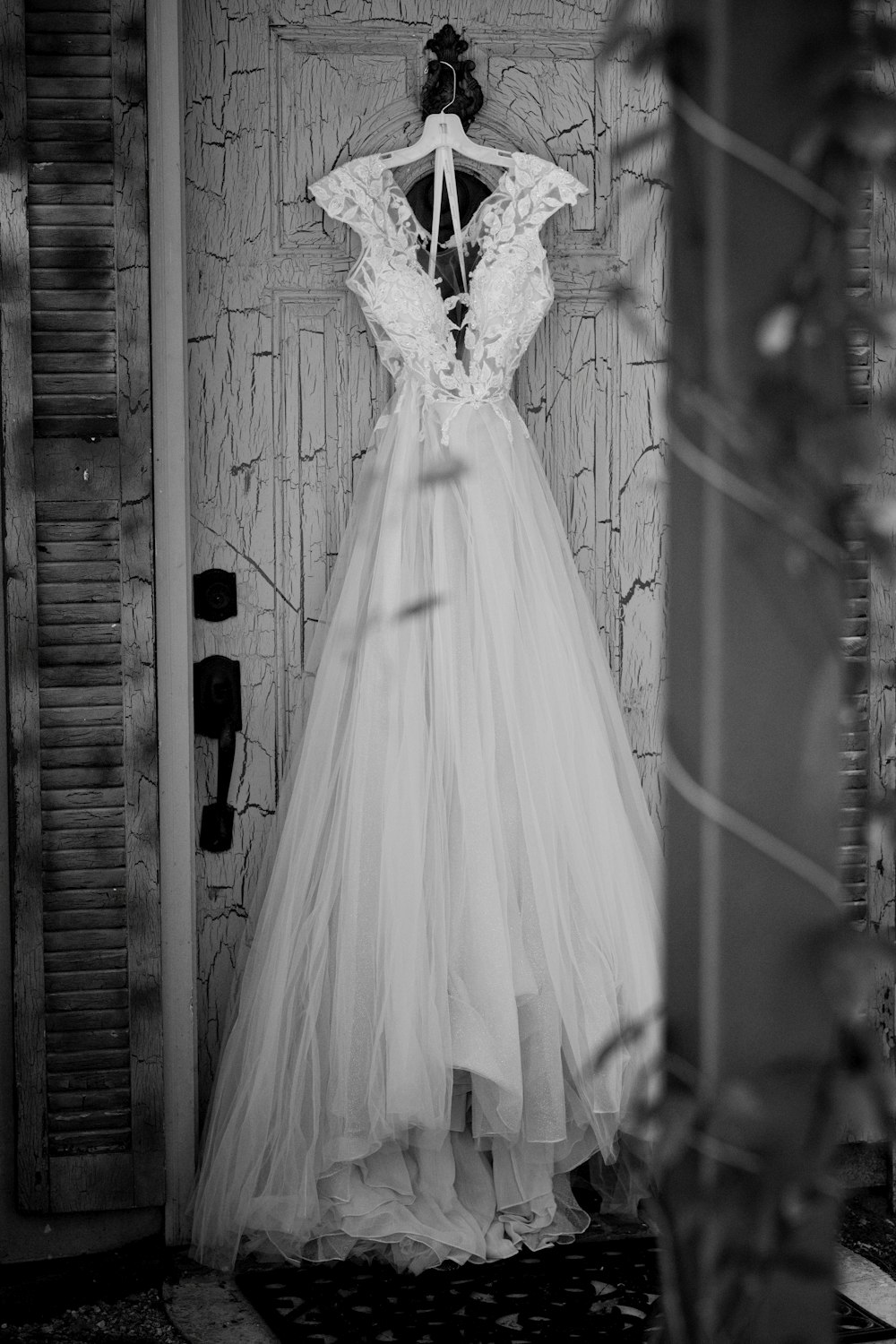 white wedding dress hanged on brown wooden door