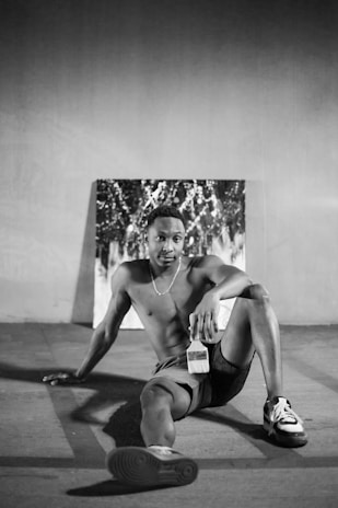 Portrait of Pavol Sarkozi in a bright blue shirt holding a paintbrush, smiling confidently in front of a freshly painted wall.