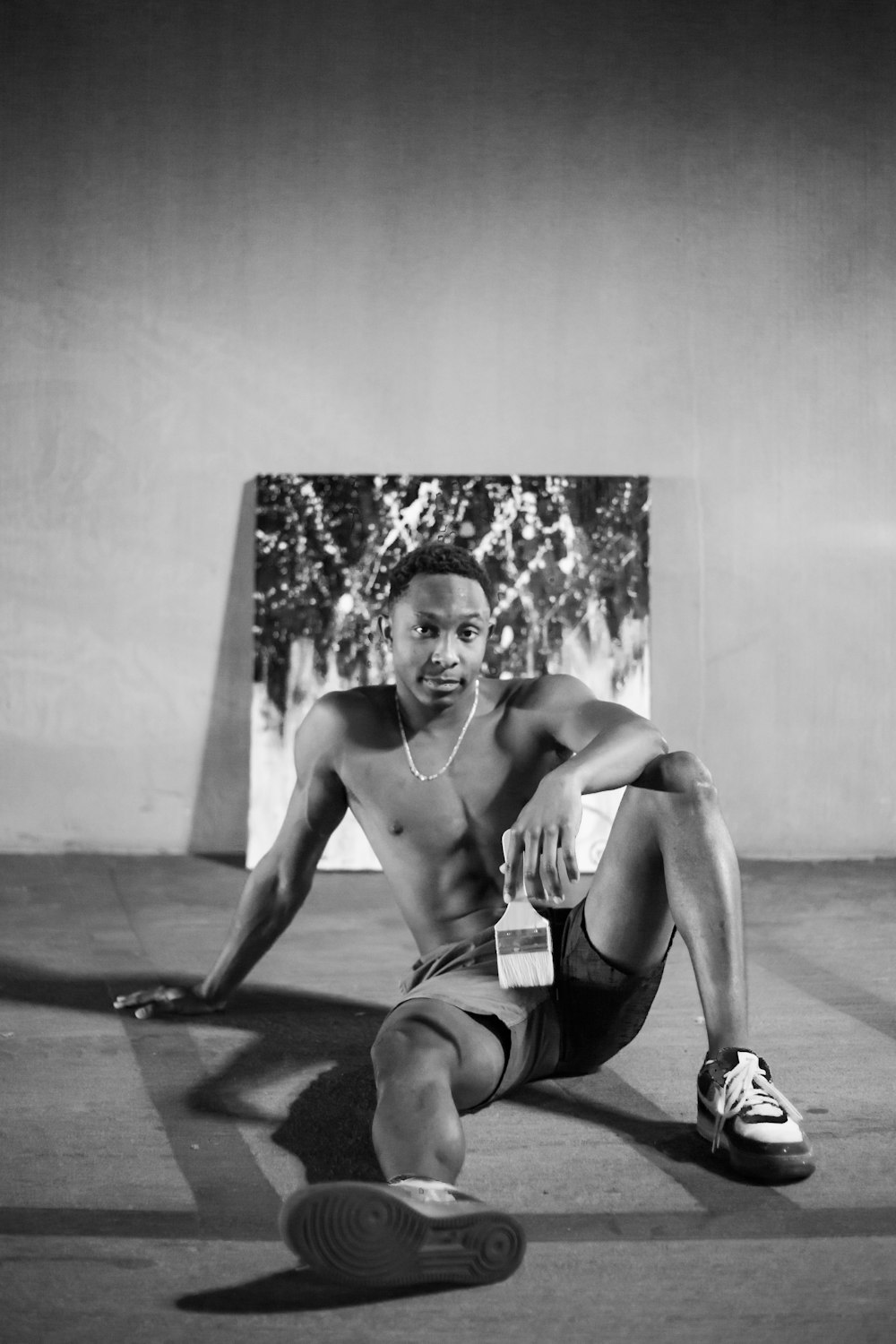 topless man in black shorts sitting on floor