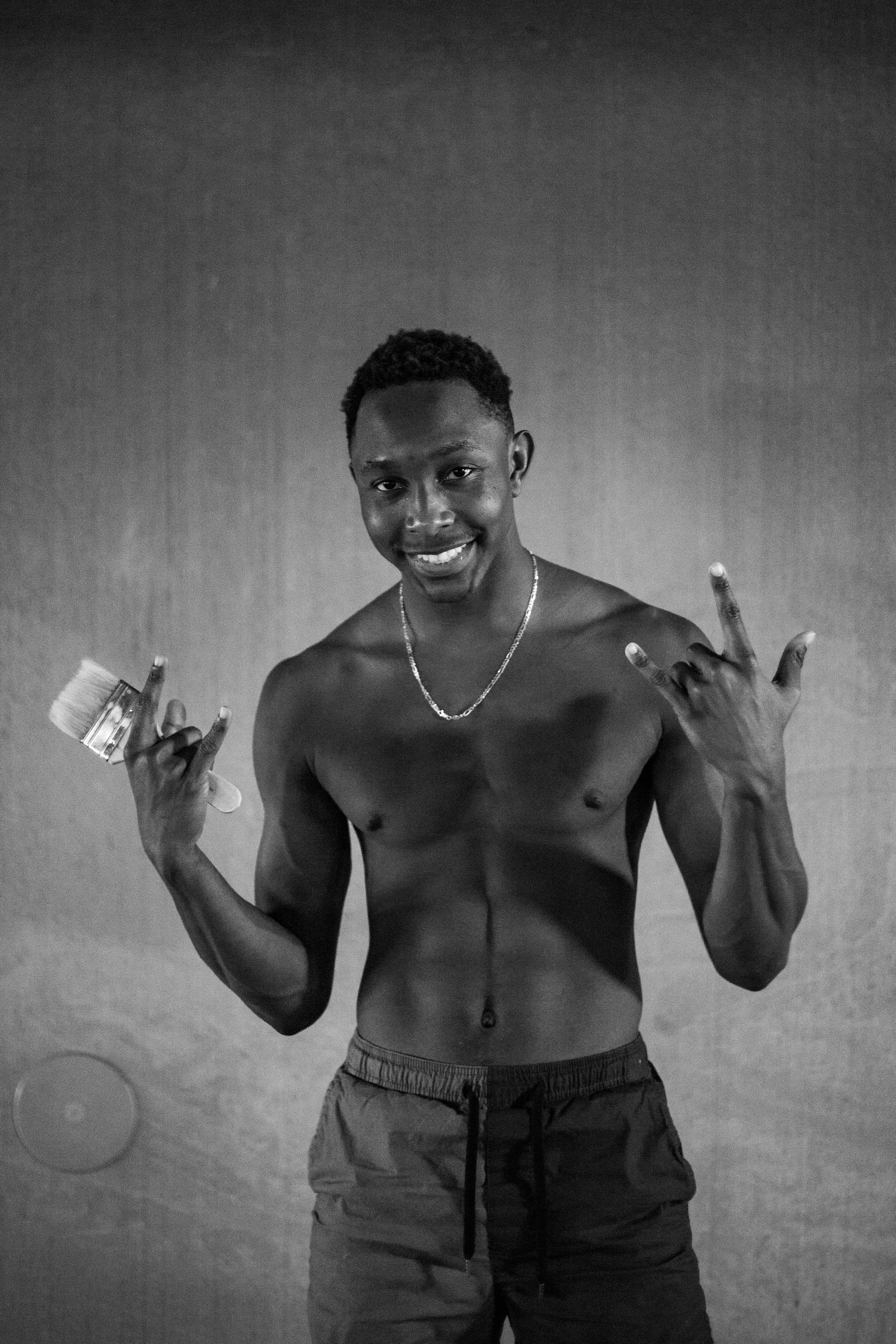 Topless man in black shorts smoking cigarette photo Free Grey Image