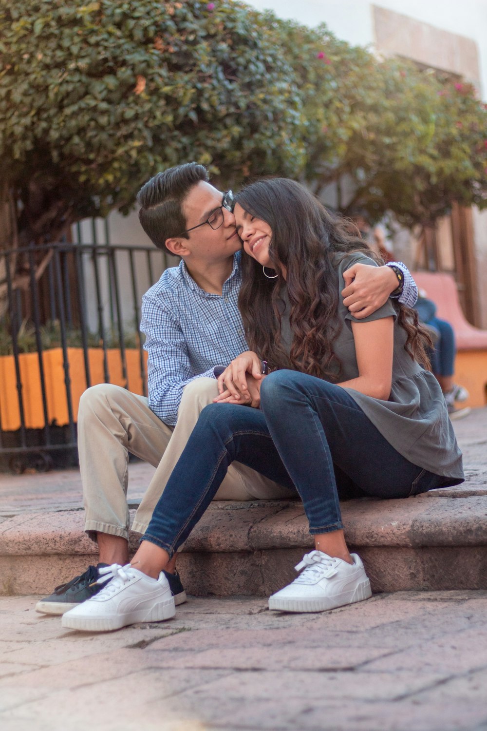 man and woman sitting on brown wooden bench during daytime