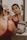 A woman applying makeup in front of a mirror, looking confident.