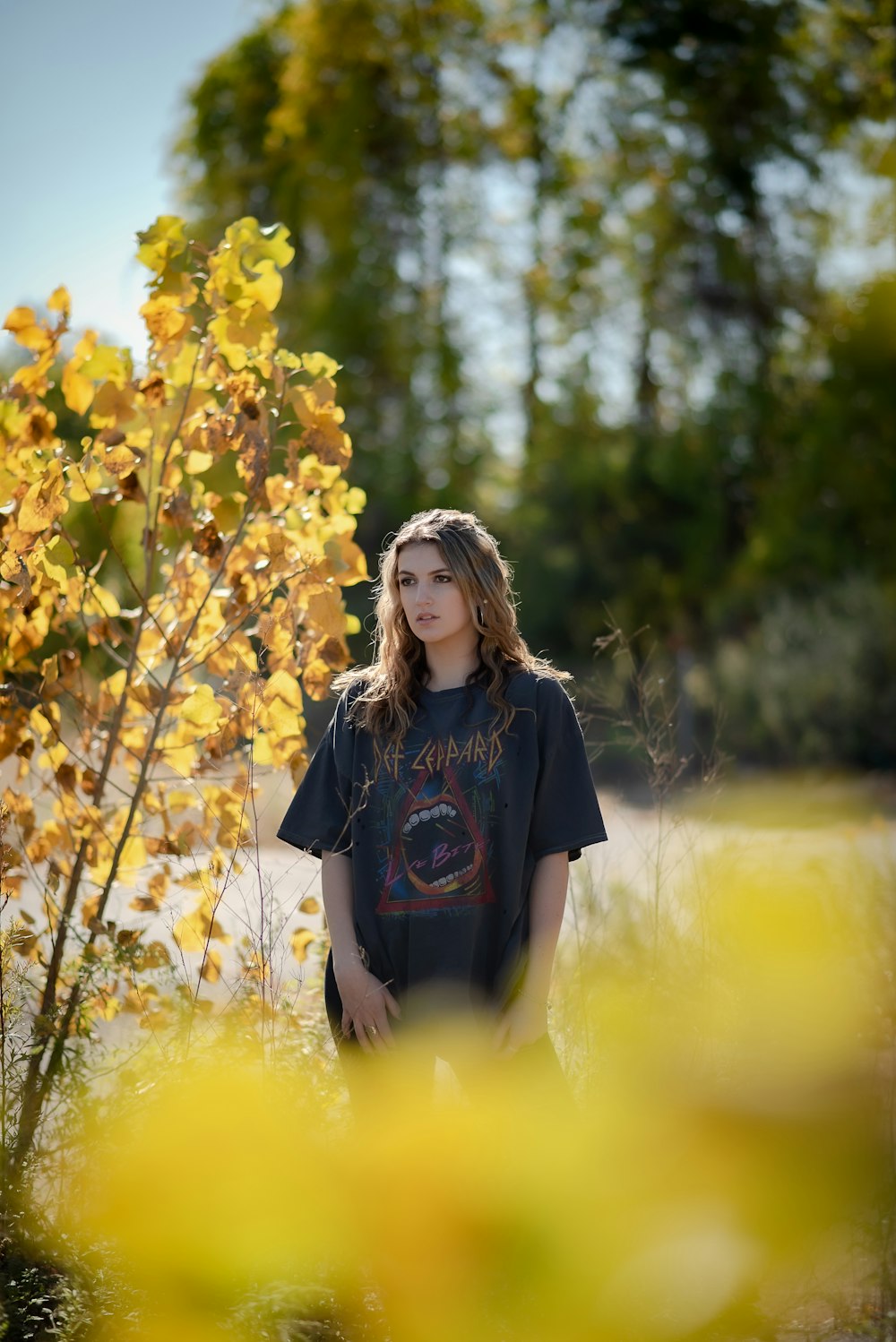 woman in black t-shirt standing on yellow flower field during daytime