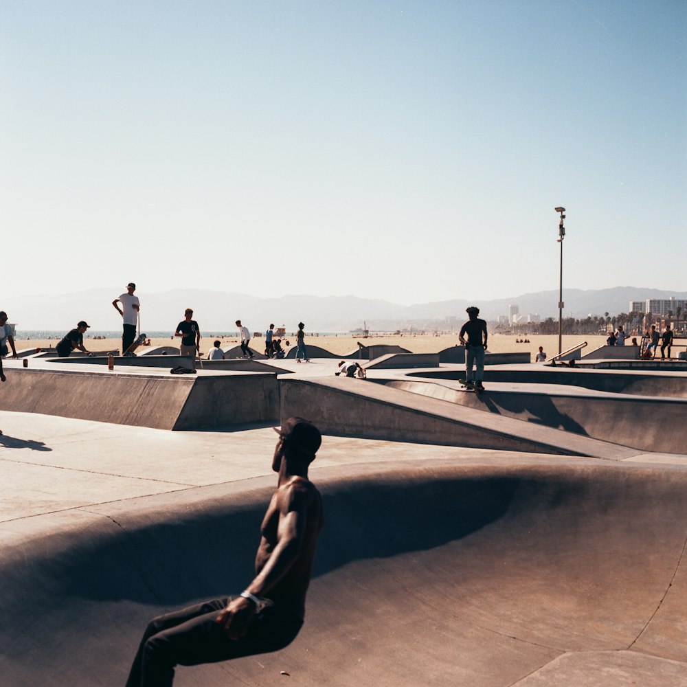 woman in black tank top and black pants sitting on concrete bench during daytime