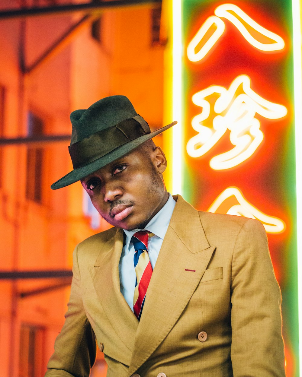 man in brown suit wearing black hat