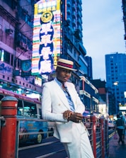 man in white coat standing on the street during daytime