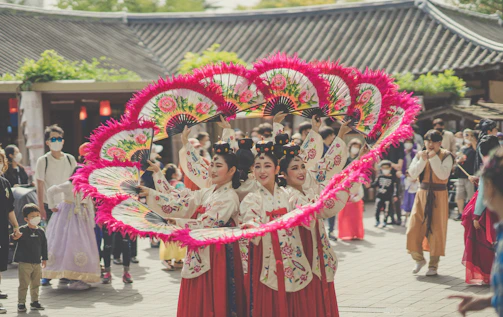 A lively cultural class with women learning traditional Korean crafts together.