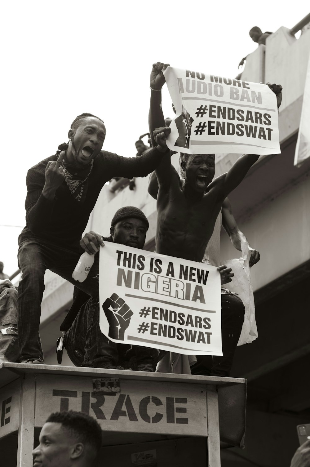 man in black t-shirt holding white and black signage