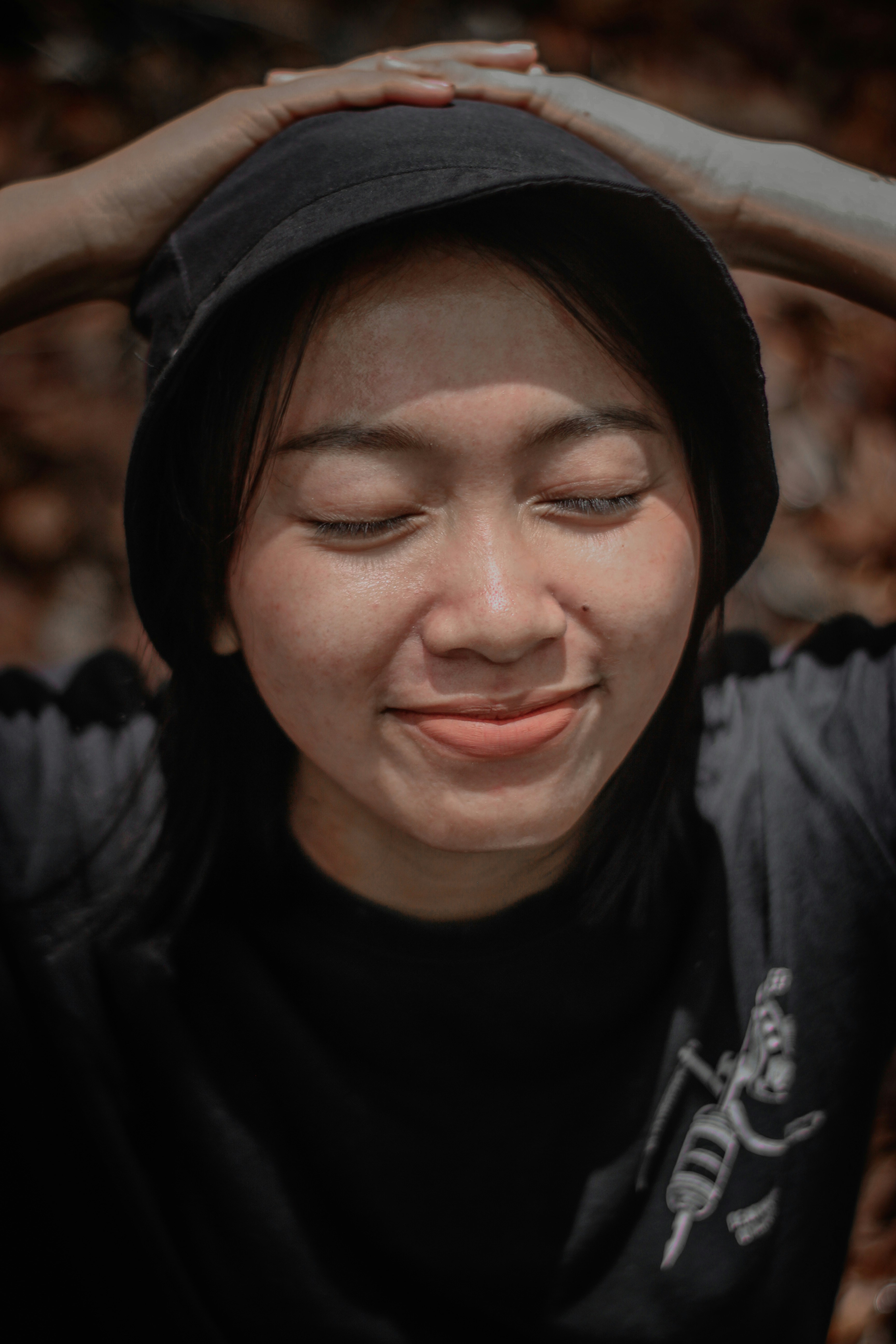 Wanita dengan kemeja leher kru hitam tersenyum