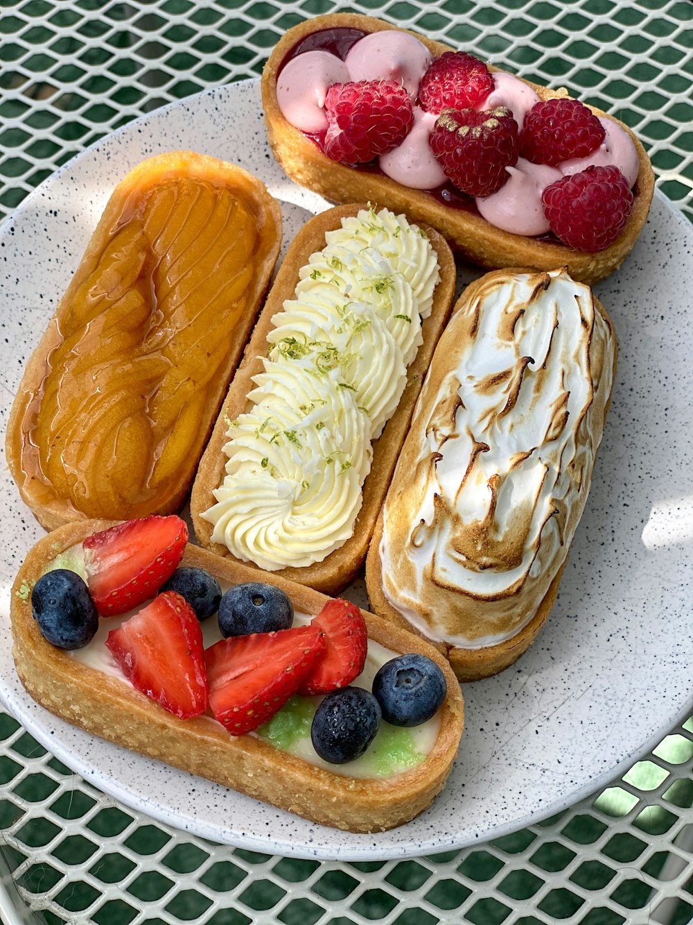 Bizcocho de fresa y frutos rojos sobre plato de cerámica blanca