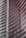 Steel and glass building facade with red horizontal slats creating a dynamic, modern architectural design.