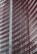 Steel and glass building facade with red horizontal slats creating a dynamic, modern architectural design.