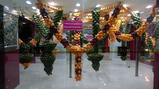 A collection of colorful amigurumi fruits arranged neatly on a light wooden shelf.