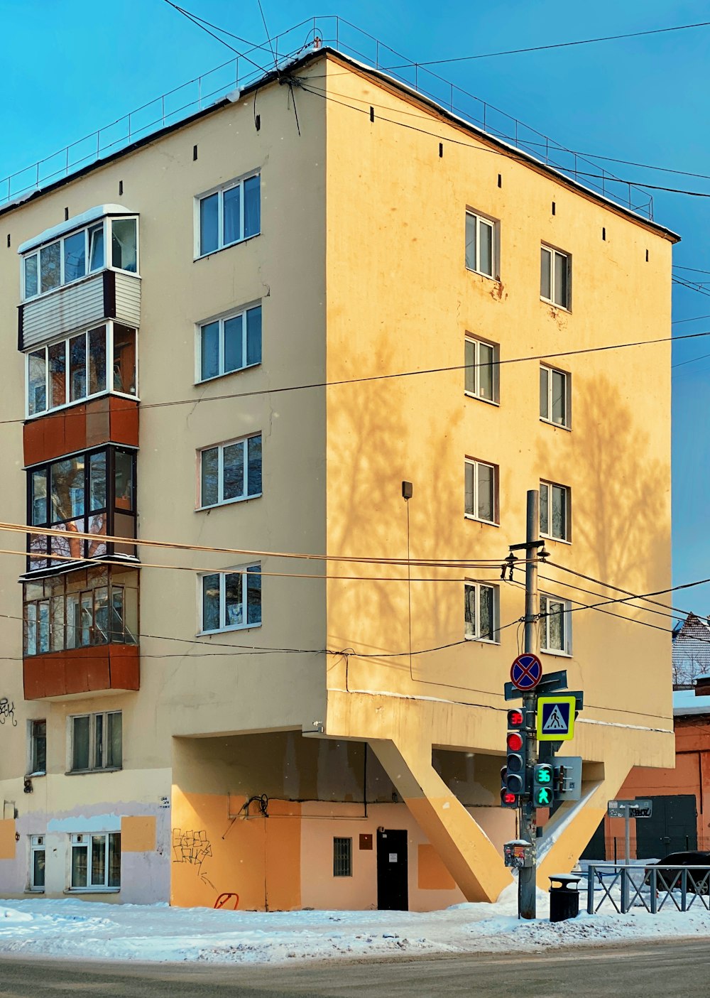 신호등 옆에 앉아있는 높은 노란색 건물
