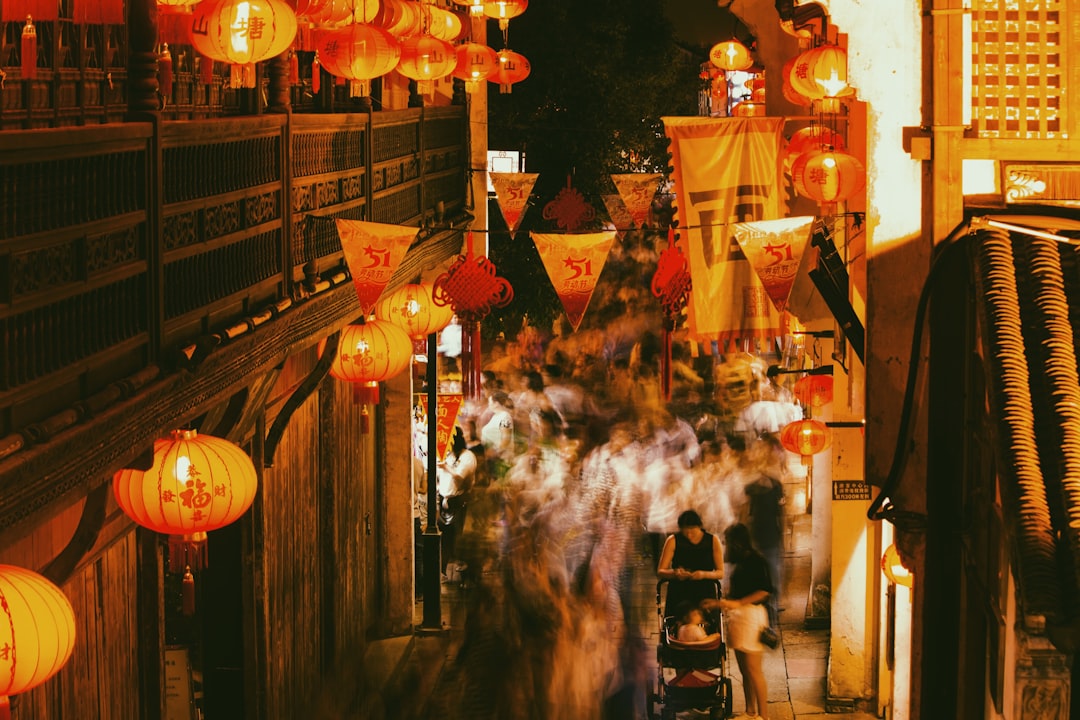 white and red paper lanterns on street during nighttime