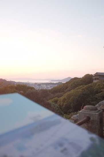 A smiling traveler holding a map, standing in front of a vibrant cityscape at sunset.