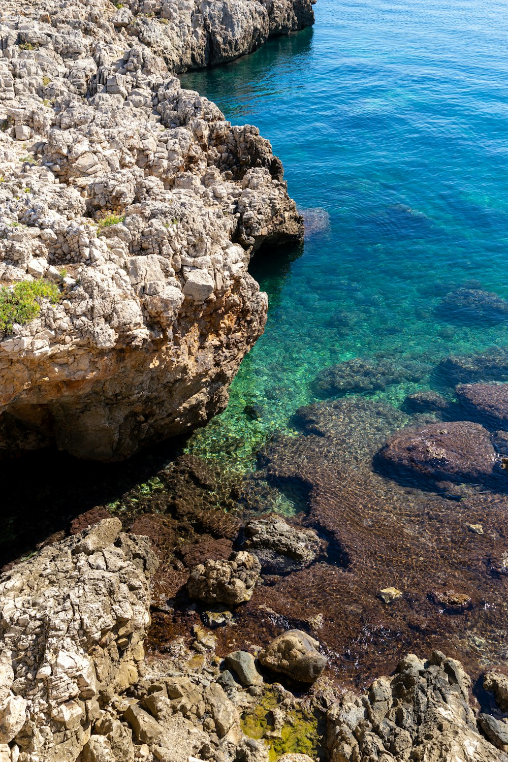 brown rock formation beside blue sea during daytime