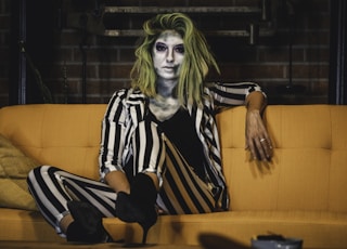 woman in black and white stripe dress sitting on orange sofa