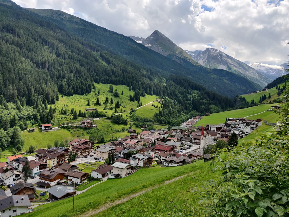 houses on green grass field near green mountains during daytime