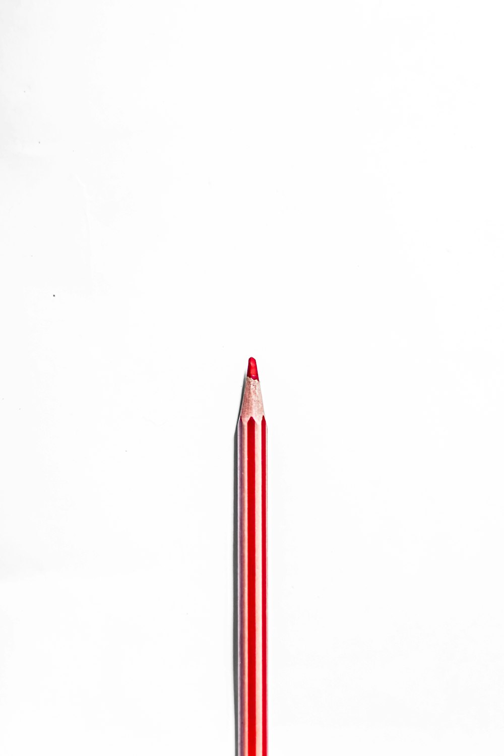 matita rossa e bianca su superficie bianca