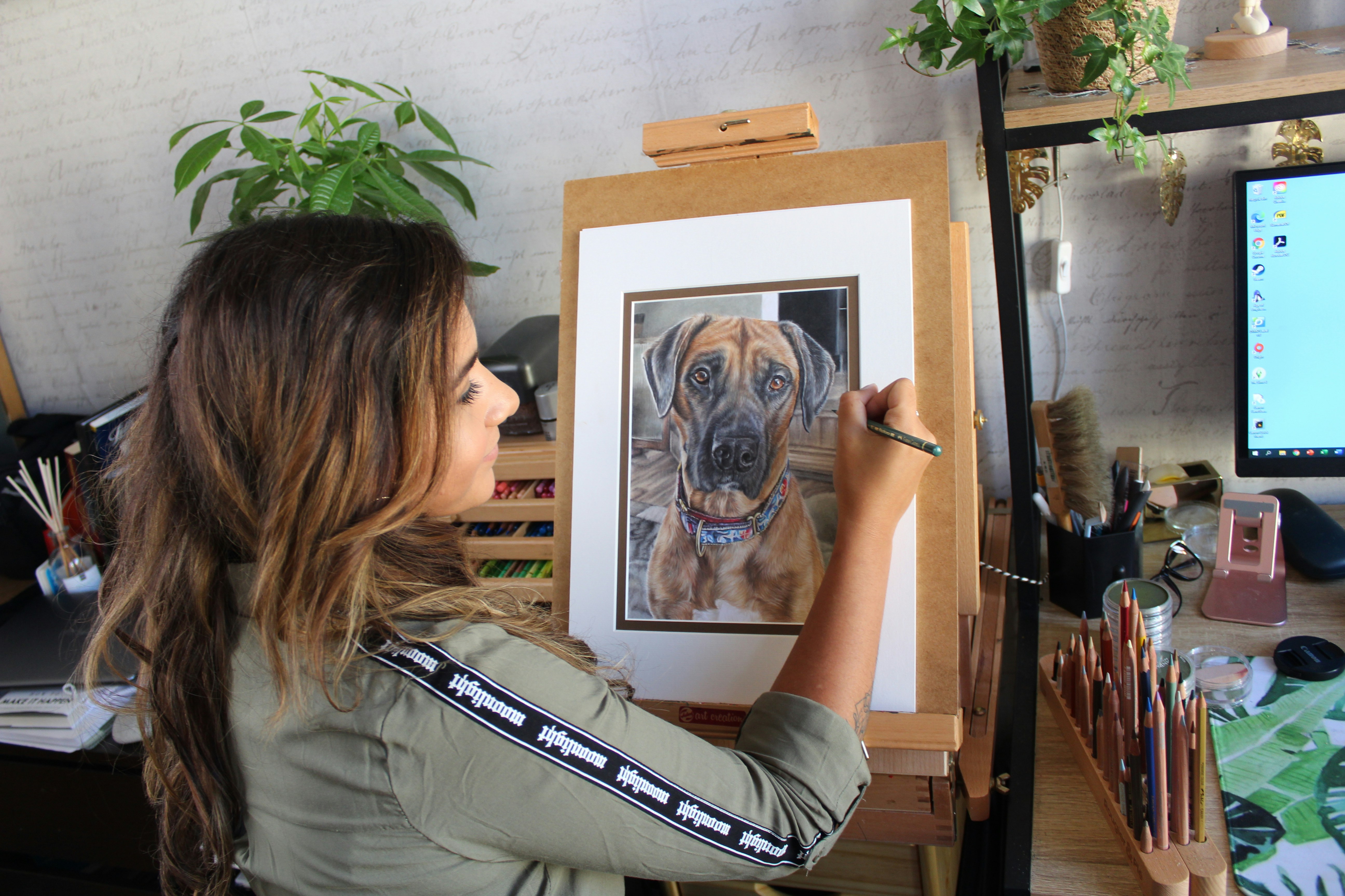 A woman is drawing a detailed picture of a dog.